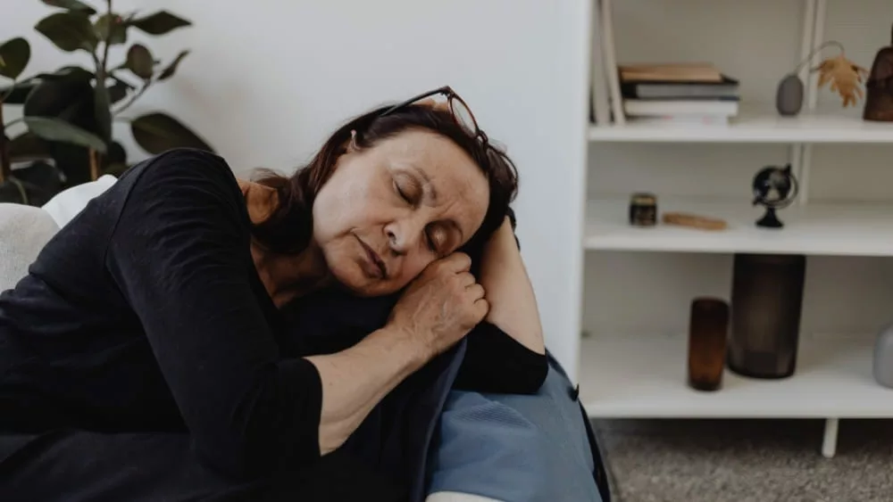 femme de 55 ans qui dort sur son canapé