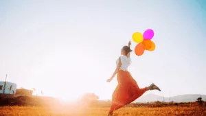 femme qui tient des ballons colorés en courant