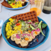 Assiette végétale colorée avec une gaufre du houmous et de la salade