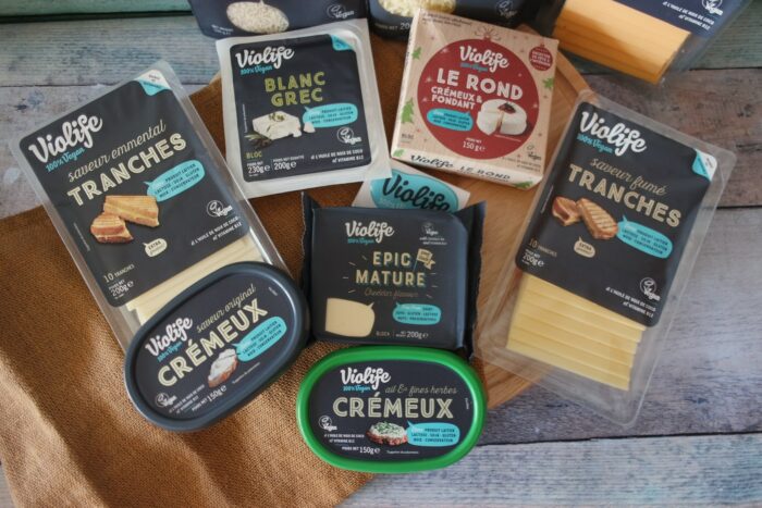 Violife assortiment: fromages vegan: tranches, fromage à tartiner, blanc grec sur planche.