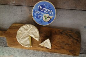 Coeur fleuri végétal Nurishh Groupe Bel camembert vegan sur planche en bois