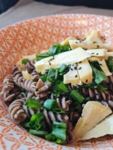 Plat de pâtes sans gluten au sarrasin avec oignon cébette et parmesan végétal Gondino