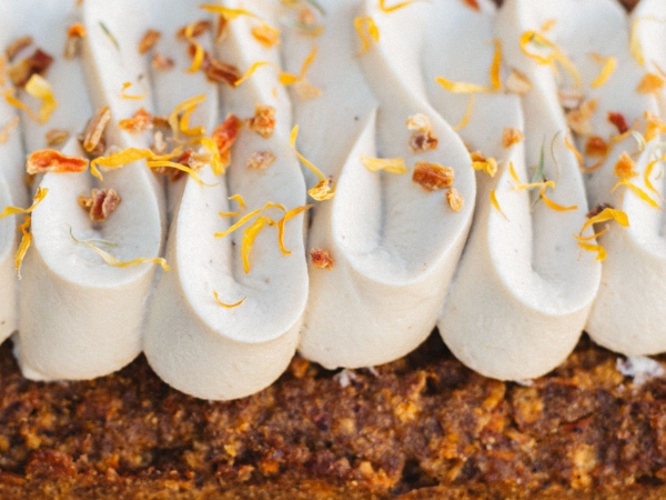 carrot cake avec crème végétale et pétales de fleurs