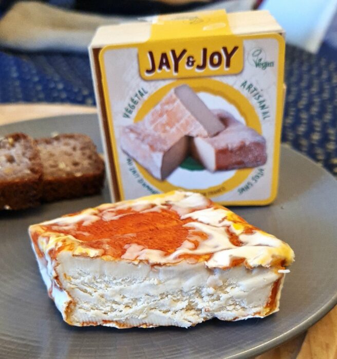 Maroilles vegan Jay & Joy Jean-Jacques sur une assiette avec packaging dans le fond de la photo