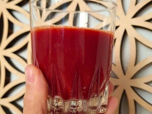 verre avec un jus rouge sous fond de fleurs de vie