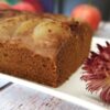 Gâteau aux pommes sur une assiette blanche avec une fleur séchée