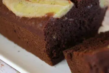 Gâteau chocolat banane moelleux avec une demi banane dessus sur une assiette blanche