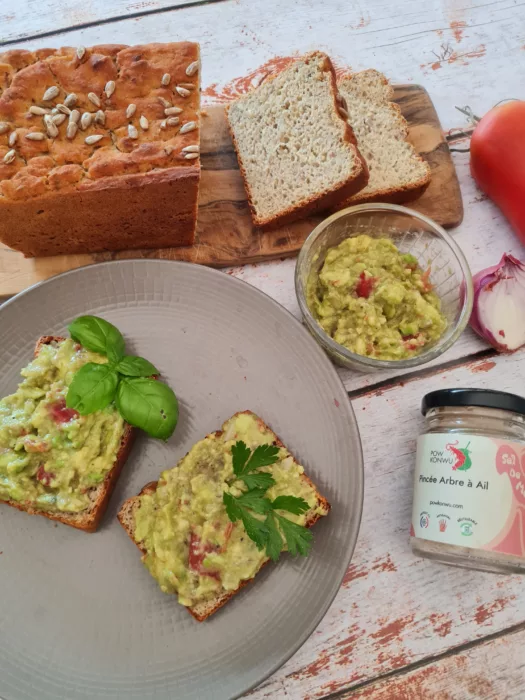 Pain sans gluten guacamole, basilic et tomate allongé avec pot d'épice Pon Konwu